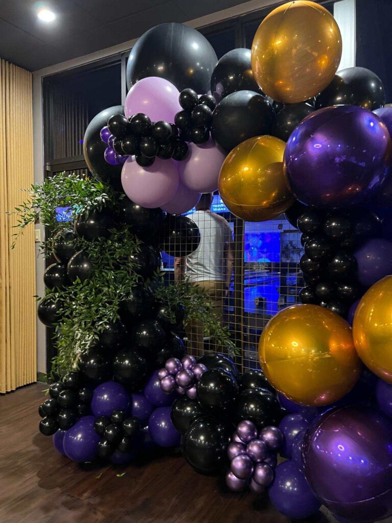 Black, purple and gold balloon arch